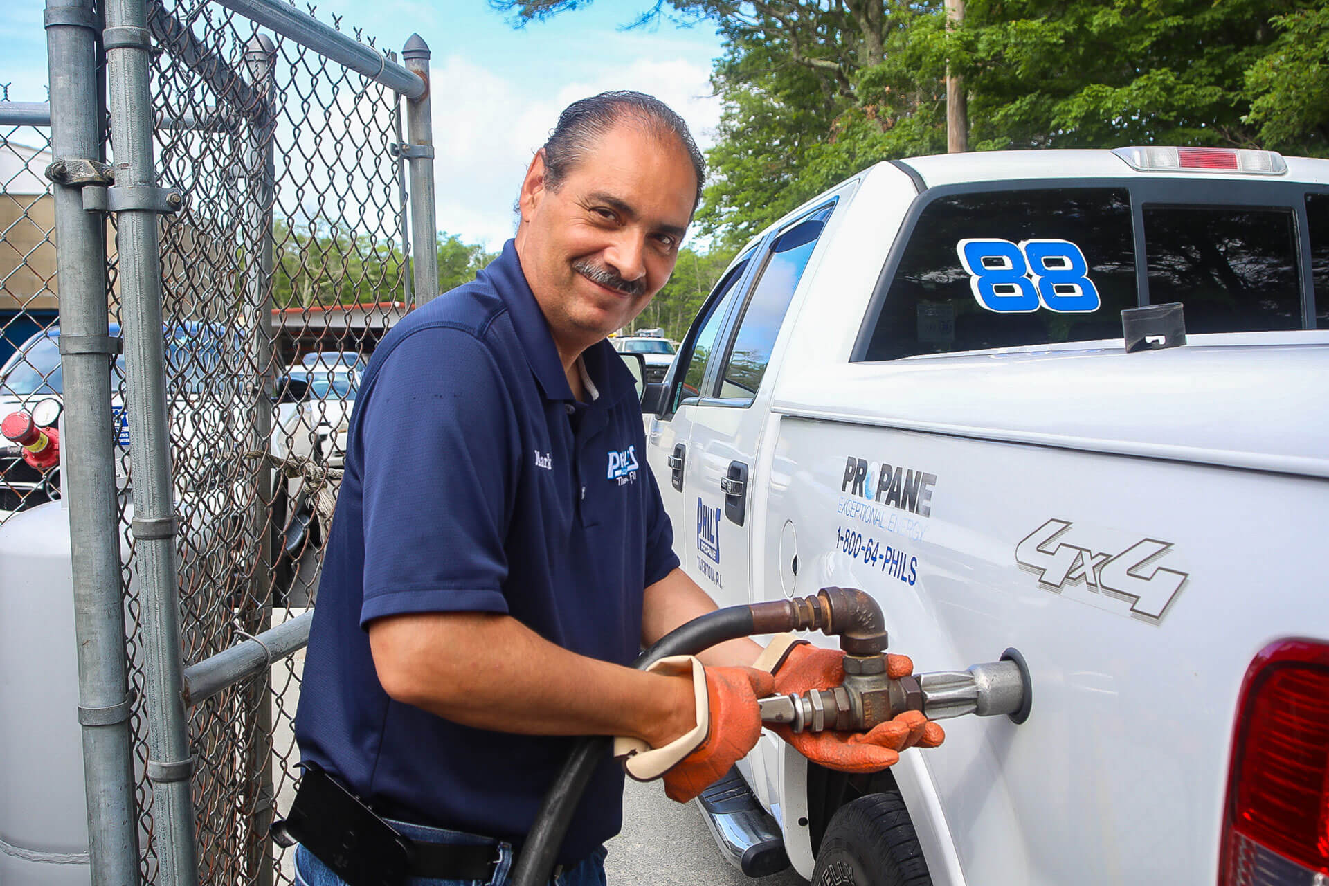 employee putting gas in a Phil's Propane truck