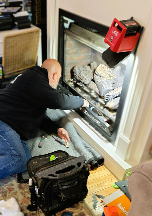 technician servicing a residential propane fireplace