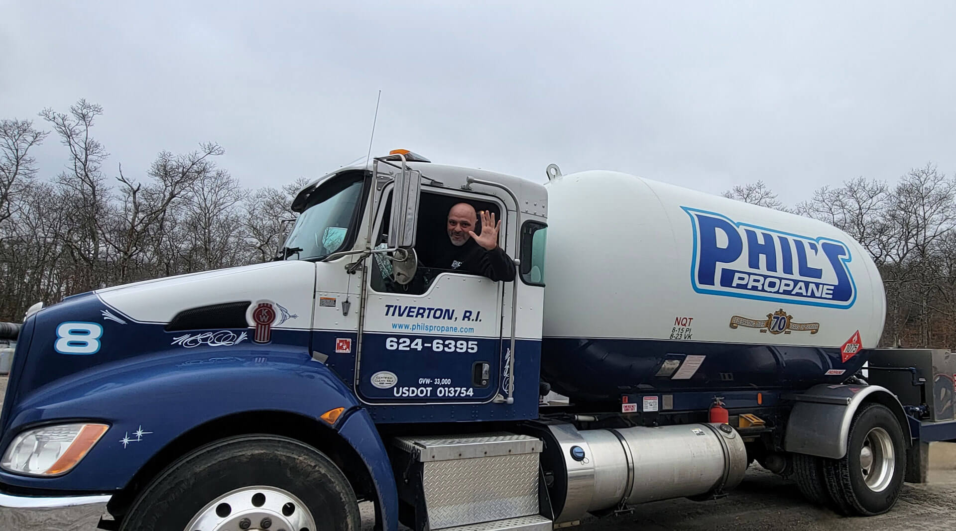 Employee waving to camera from Phil's Propane fuel truck